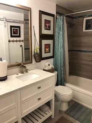 Combined shower/bathtub, towels, soap, toilet paper