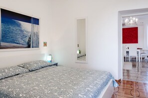 A bedroom with a bed, a painting, a mirror, and a dining area with chairs. - Bright apartment of about 85 square meters with balcony, which can accommodate up to 4 people, located on the first floor of a period building without lift. The property enjoys an excellent position, being situated in a panoramic area (sea view) and surr (La Spezia)