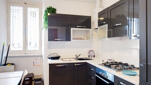 Una cocina moderna con armarios oscuros, una estufa a gas y un lavamanos.