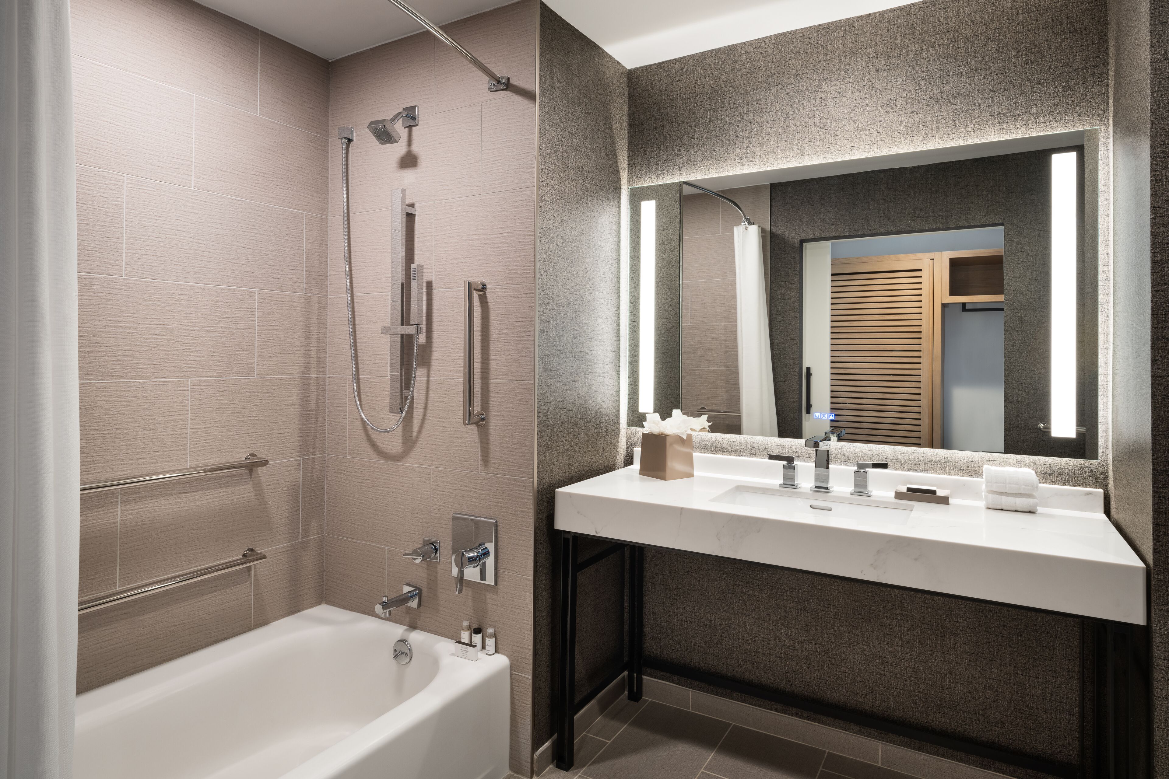 A modern bathroom with a bathtub, a shower, and a vanity with a mirror.