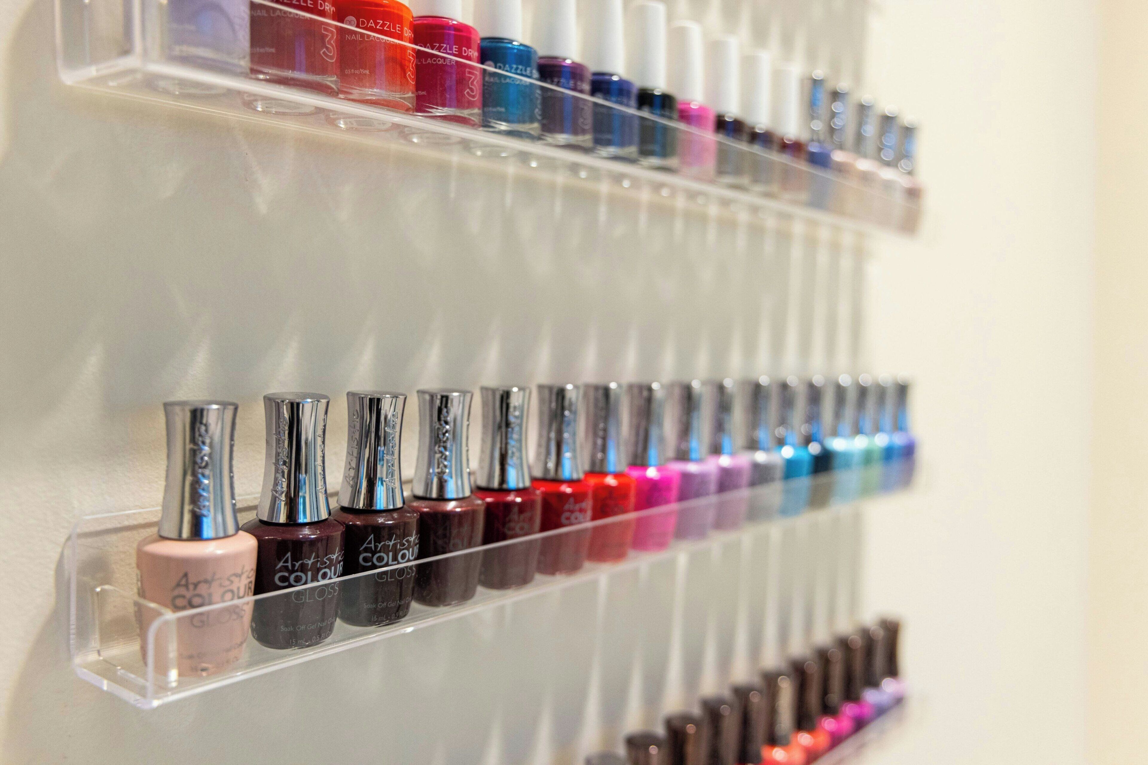A wall-mounted display of nail polish bottles in various colors.