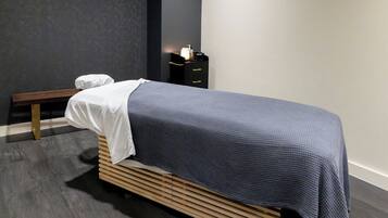 A modern bedroom with a bed, bedside table, and a bench.