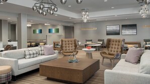 Una sala de estar moderna con un sofá, sillones y una mesa de centro.