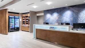 A modern hotel lobby with a reception desk, a beverage refrigerator, and a well-stocked snack bar. - SpringHill Suites by Marriott Durham City View (Durham)