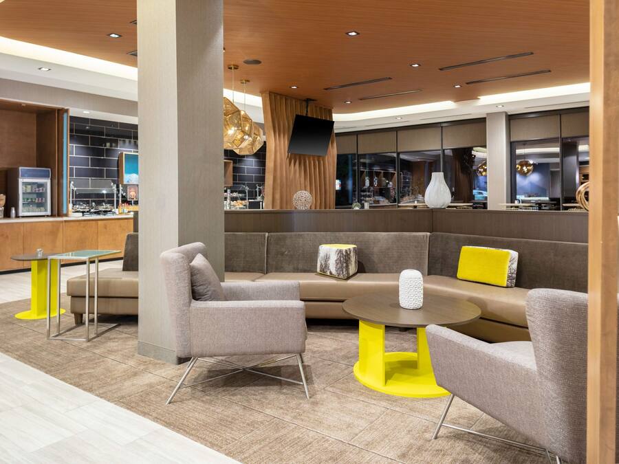 A modern lounge area with a sofa, armchairs, and a small table.