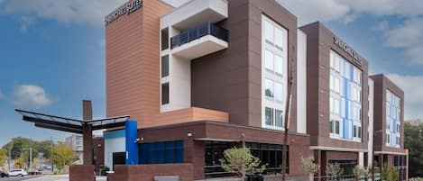 A modern hotel with a flat roof, large windows, and a prominent sign reading "SPRINGHILL SUITES."