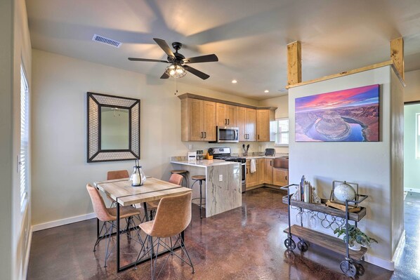 A modern kitchen with wooden cabinets, a central island, and a ceiling fan. - Modern Retreat: 3 Blocks to Dtwn Williams + Rte 66 (Williams)