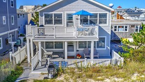 A two-story house with a balcony, a covered patio, and a small deck area. - Beach Front! (Long Beach)