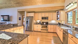 A modern kitchen with granite countertops, wooden cabinets, stainless steel appliances, and a wooden ceiling. - Ski + Bike: Home w/ Deck & Hot Tub in Granby! (Granby)