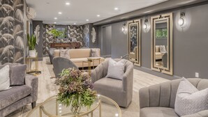 A modern living room with grey sofas, a coffee table, and a decorative plant. - The George Luxury Boutique Inn (Napa)