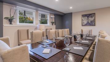 A conference room with a long table, multiple chairs, and a world map on the wall.