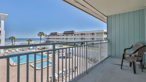 A balcony with a view of a swimming pool and beach. - Ocean View Studio#204-Newly Renovated! (New Smyrna Beach)