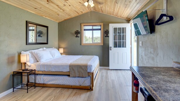 A bedroom with a bed, bedside table, and a ceiling fan. - Cabin "The Eagles Nest" (Custer)