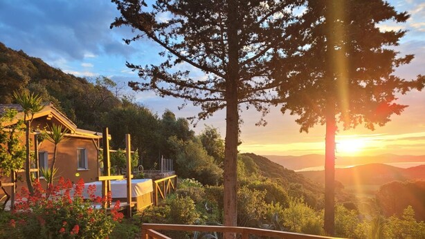 A wooden deck with a view of a mountainous landscape and a sunset. - Wonderful private villa for 6 guests with WIFI, hot tub, A/C, TV, patio and pets allowed (Monte Argentario)