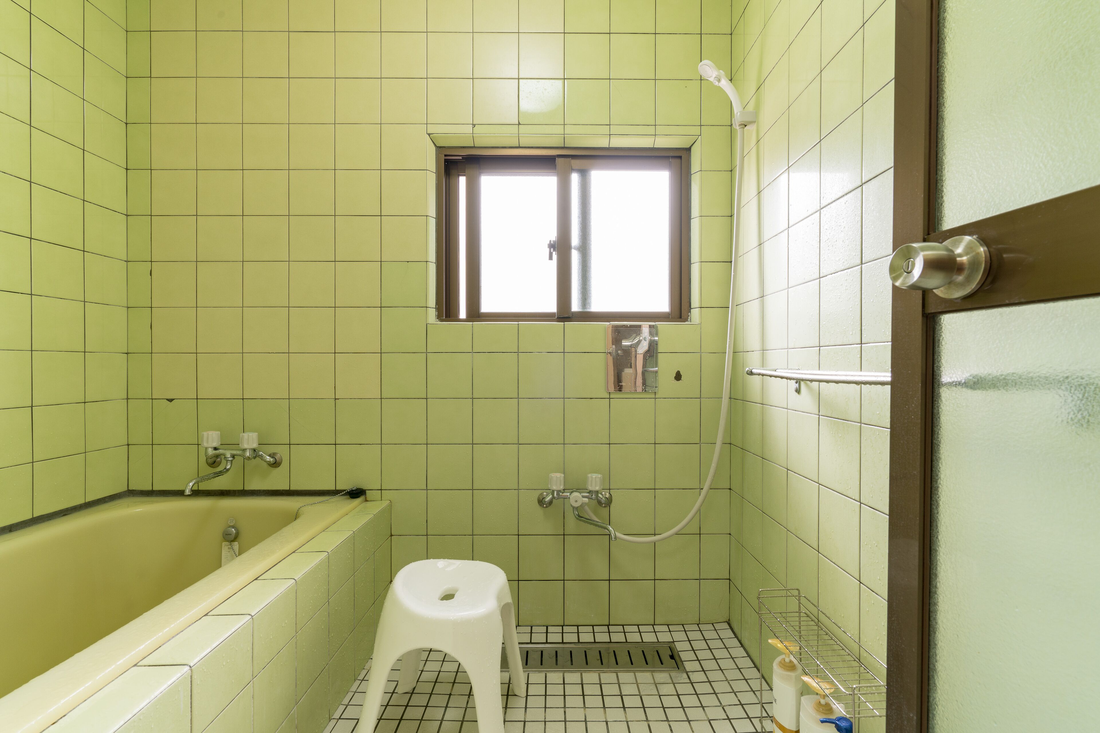 Ein Badezimmer mit Badewanne, Dusche, Fenster und Toilette.