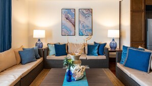 Un salon moderne avec deux canapés, une table basse et des éléments décoratifs tels qu’un vase et des  œuvres d’art mural.