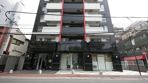 A multi-story hotel with a modern facade, featuring a prominent red stripe and a glass entrance. - ZONK HOTEL HARUYOSHI-TERAMACHIDORI (Fukuoka)