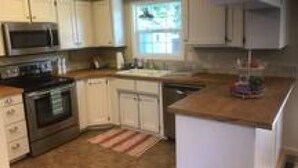 A kitchen with white cabinets, a microwave, an oven, and a dishwasher.