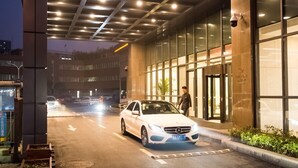 The exterior of the Jinling Jialong Hotel with a modern facade, illuminated signage, and a car parked in front. - Hotel Jialong By Jingling (Hefei)