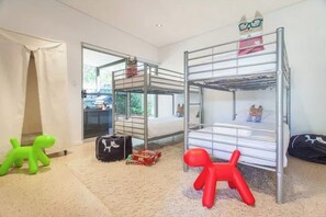 Quarto com beliches, uma janela e vista para o exterior.