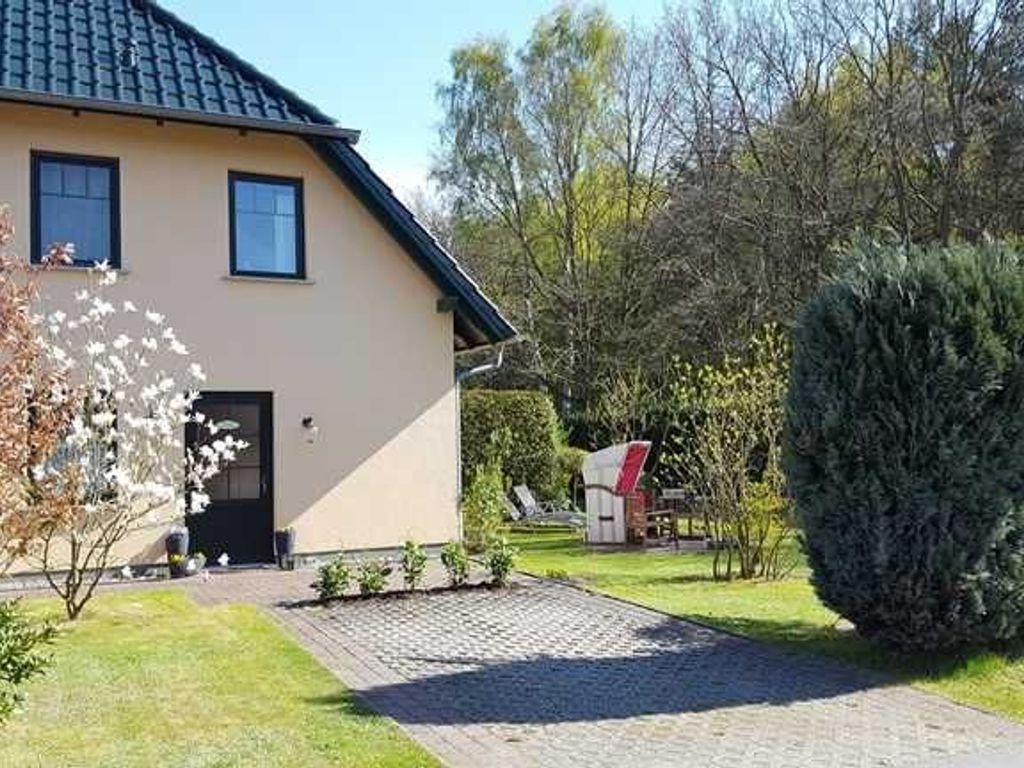A two-story building with a paved driveway, a lawn, and a small garden area.