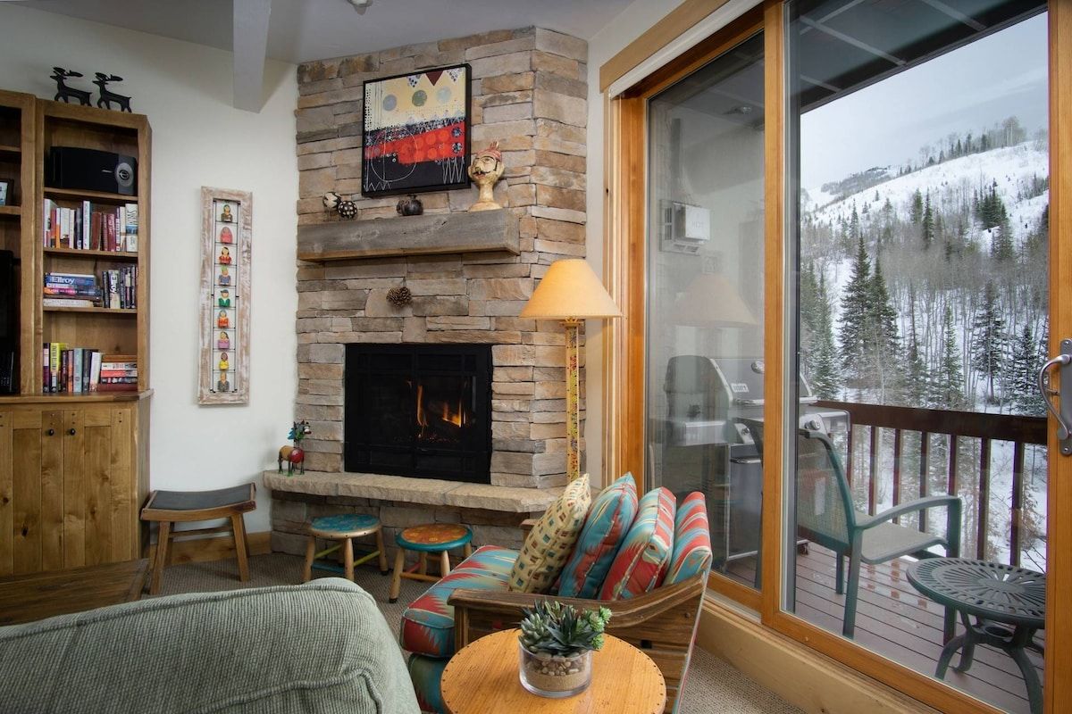 Ample seating by the fireplace with gorgeous views visible through the sliding door—perfect for cozy gatherings.