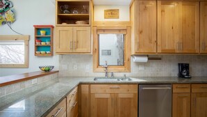 A kitchen with wooden cabinets, a stainless steel dishwasher, and a window above the sink. - Best Location-True Hike In/Out TH w/Slope Views-Heated Pool-HotTub-Gym-W/D in Unit-Fireplace-Updated (Steamboat Springs)