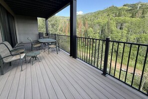Large deck with stunning mountain views, comfortable seating, and a dining area for outdoor meals.