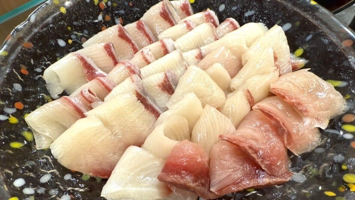 Een pan met verse visfilets en calamares.
