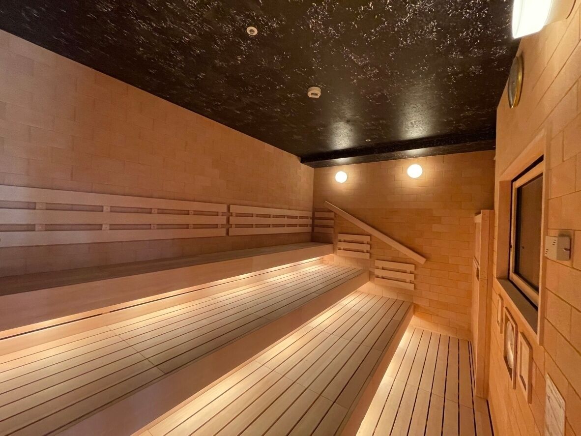 Una sala de sauna con bancos de madera y techo inclinado.