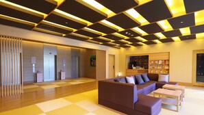 A modern lobby with a checkered floor, a sectional sofa, and a bookshelf. - Onyado Nono Kanazawa Natural Hot Spring (Kanazawa)