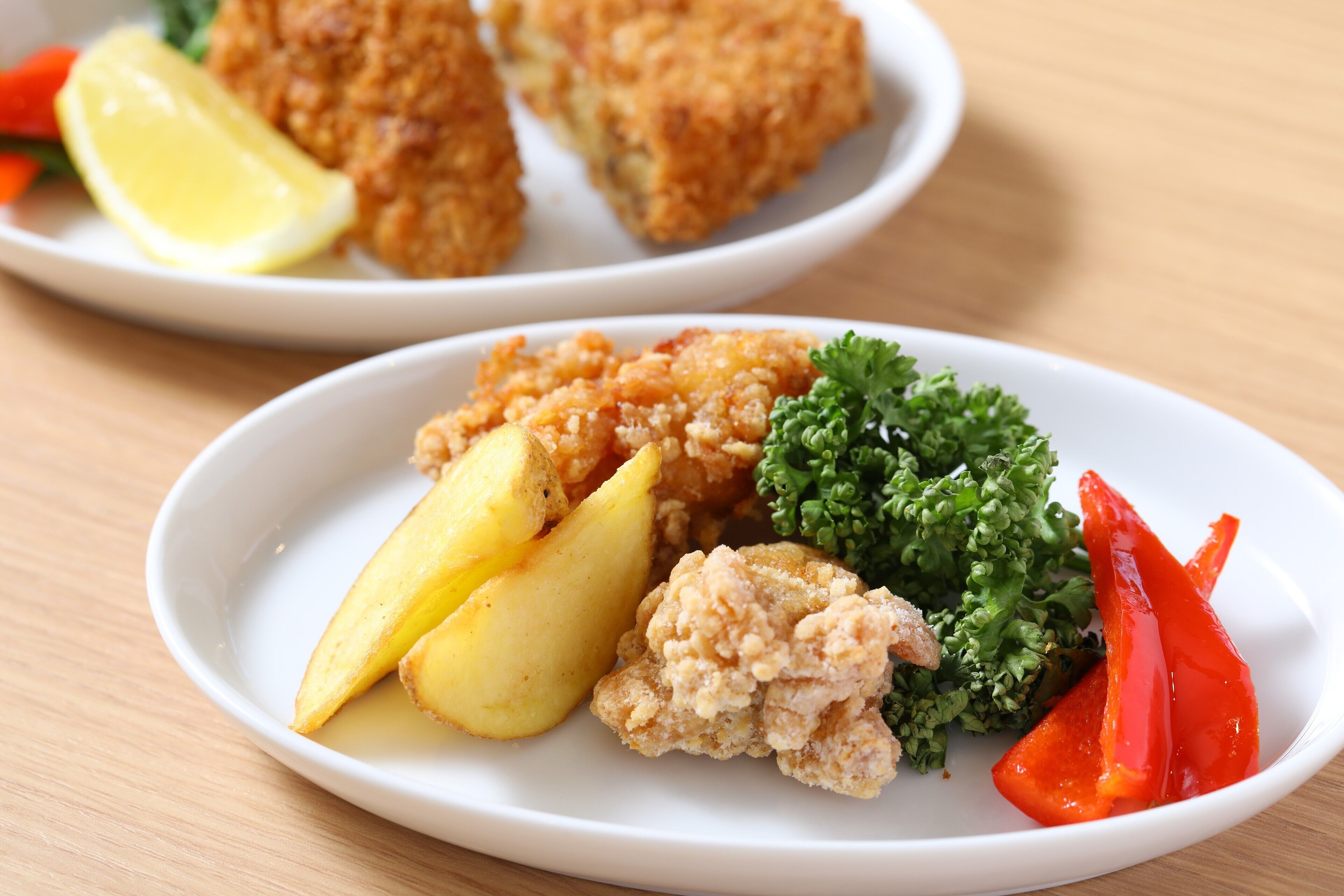 Un plato con pollo empanizado, patatas y verduras.
