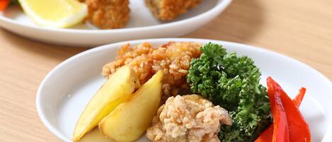 Un plato con pollo empanizado, patatas y verduras.