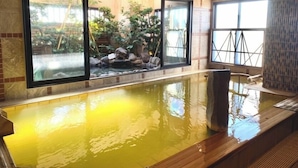 An indoor swimming pool with a view of a landscaped garden through large windows. - Onyado Nono Kanazawa Natural Hot Spring (Kanazawa)