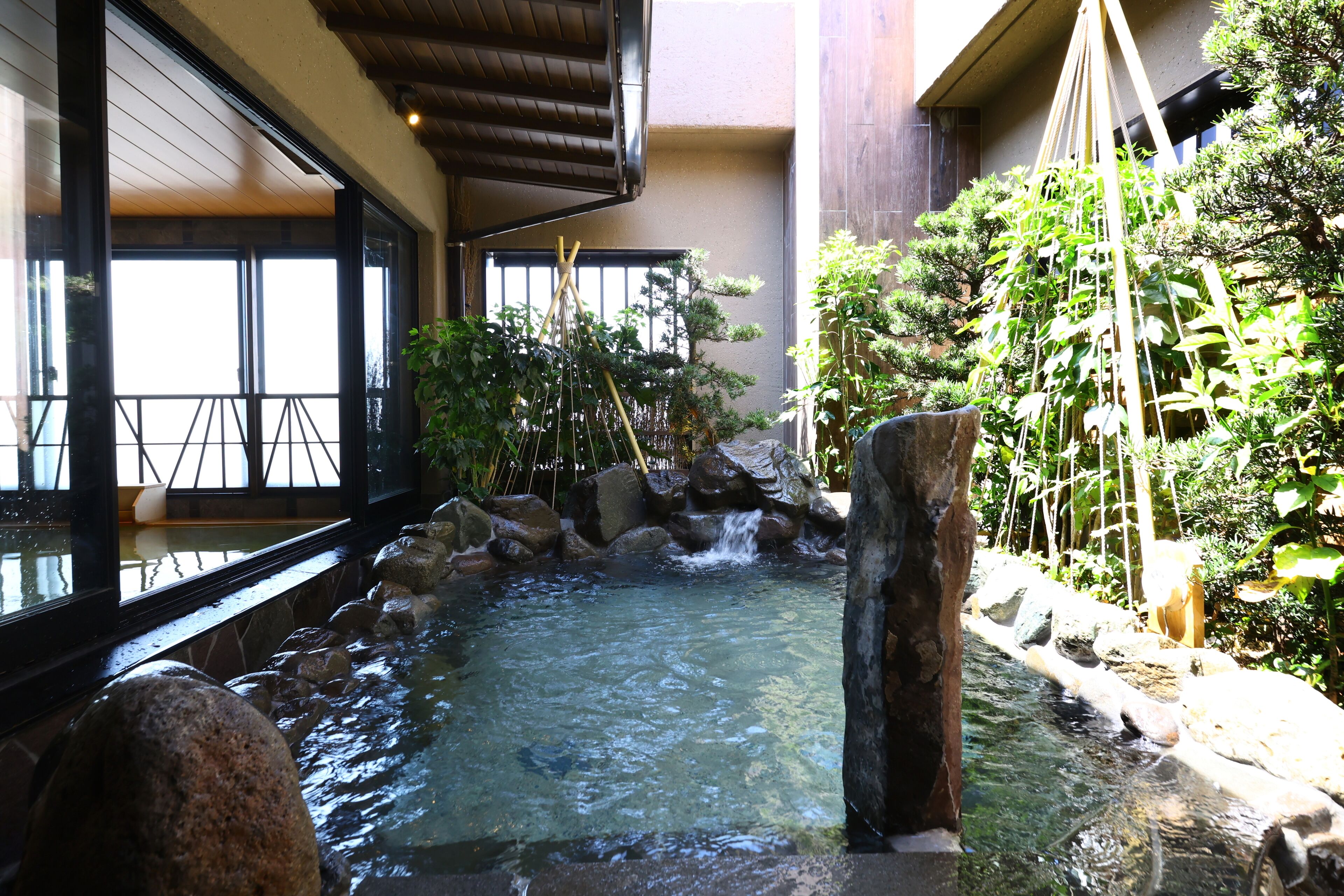 A traditional Japanese garden with a koi pond, bamboo, and rocks.