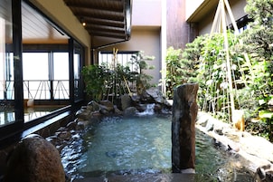 A traditional Japanese garden with a koi pond, bamboo, and rocks.