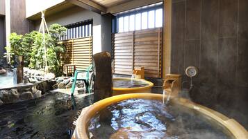 Un onsen japonés tradicional con baños de piedra y una estructura de madera.