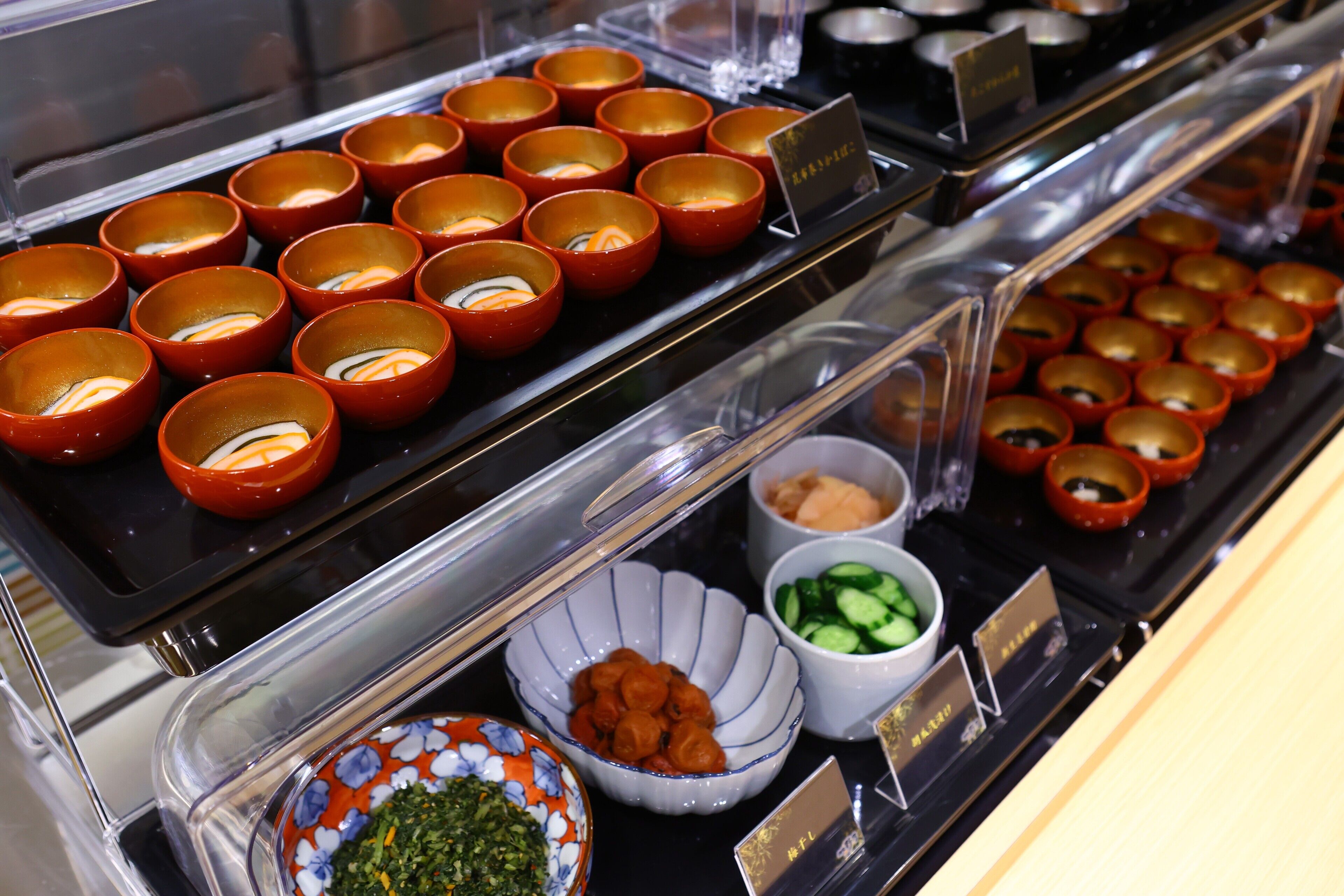 Een buffet met diverse gerechten, waaronder soepkommen, salades en andere maaltijden.