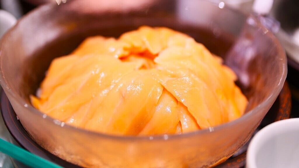 A bowl of sliced orange fruit.