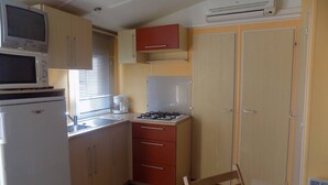 A compact kitchen with a microwave, stove, and refrigerator.