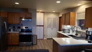 A modern kitchen with wooden cabinets, stainless steel appliances, and a built-in oven.