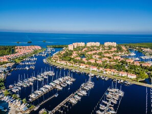 An aerial view of a marina with numerous boats docked, surrounded by residential buildings and lush greenery. - Your Waterfront Retreat at Burnt Store Marina (Punta Gorda)