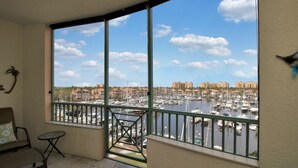 A balcony with a view of a marina and buildings. - Your Waterfront Retreat at Burnt Store Marina (Punta Gorda)