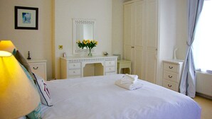 Ein Hotelzimmer mit einem Bett, einem Schminktisch, einem Schrank und einem großen Kleiderschrank.