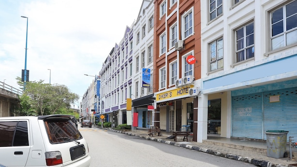 A street view with a hotel named 'DKER'S HOTEL' on the right, featuring a closed shutter and a trash bin. - OYO HOME 90244 Dkeris 2bhk Apartment (Malacca City)