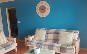 Relax in this inviting space with a comfortable sofa, a small table, and a plant.