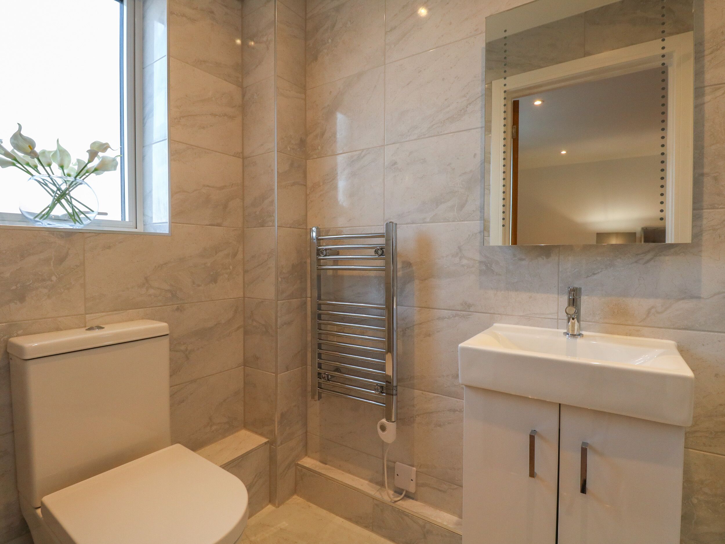 Un baño moderno con inodoro, ducha y lavabo.