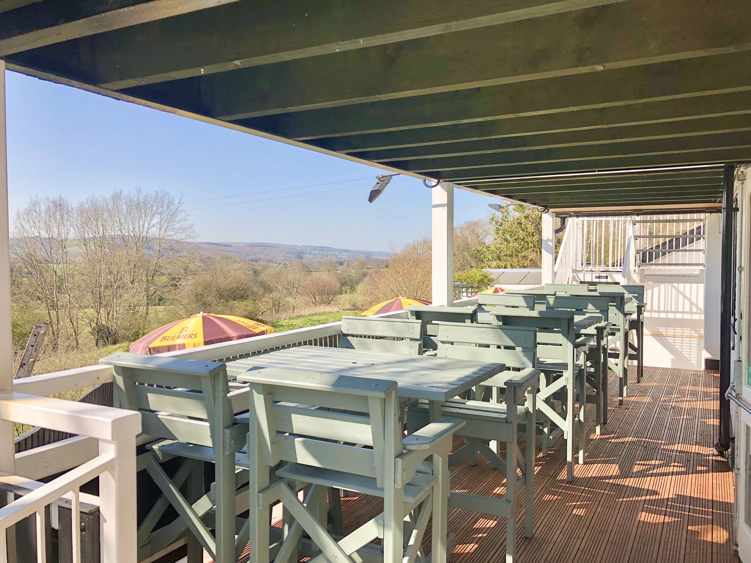 Un espace extérieur abrité, doté de tables et de chaises, offrant une vue sur un paysage pittoresque.