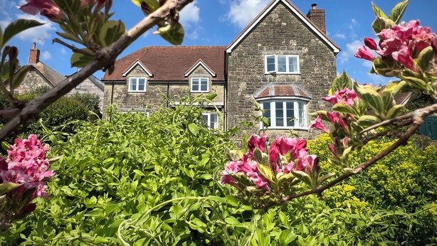 A stone house with a traditional design, featuring a central bay window and a symmetrical facade. - Samstone (Shaftesbury)