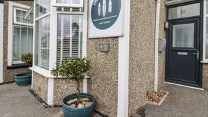 A building with a sign that reads "The Three Tees" and a contact number.